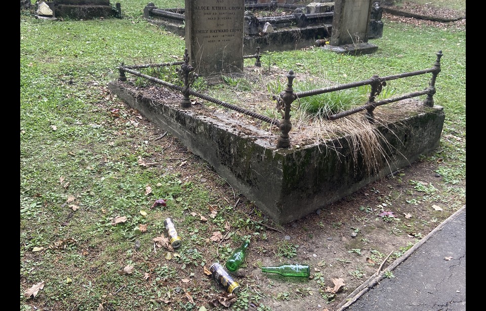 Empty beer bottles litter the front of gravestones: Photo Quinn Plunkett 