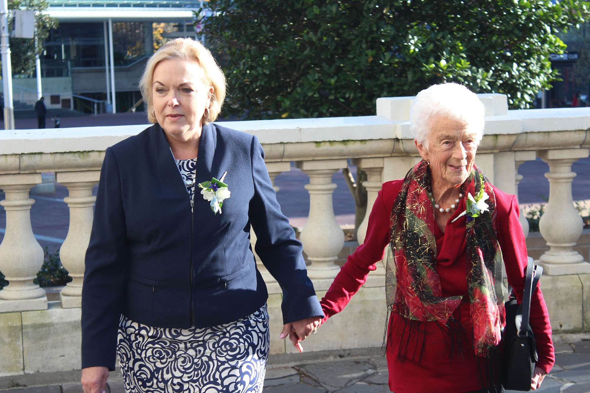 Two elderly ladies holding hands